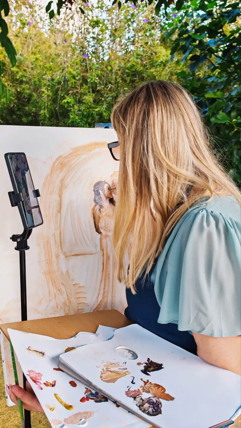 Wedding artist Marta blocking in a live painting of the bride and groom at a Spanish venue