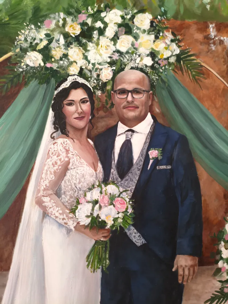 Wedding portrait detail of a bride and groom beneath white flowers and green drapery
